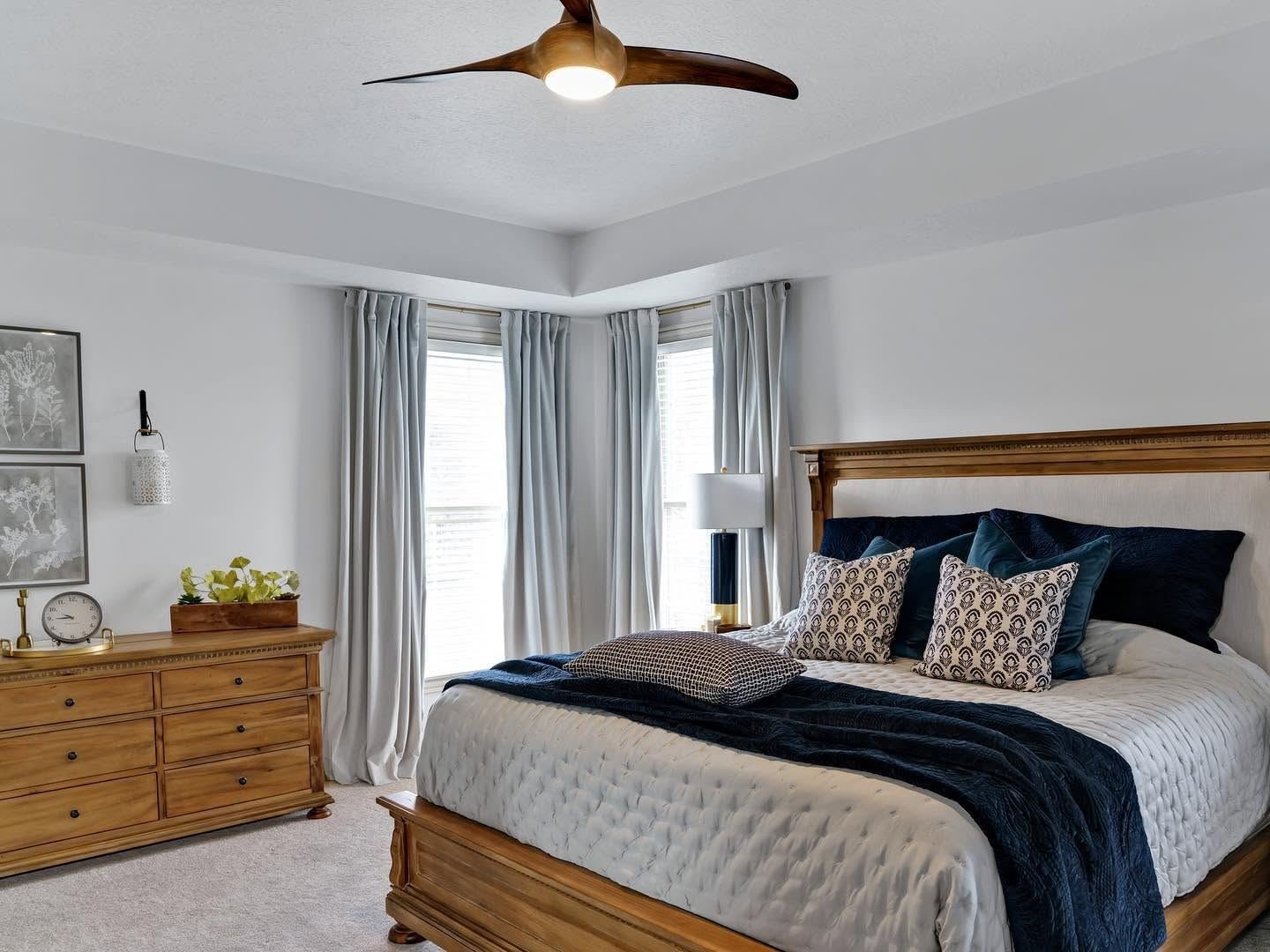 Serene bedroom with navy velvet bedding and pale grey curtains